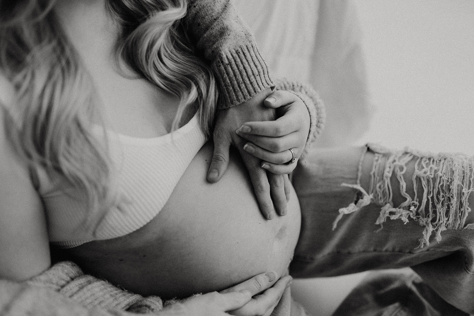 hands touching pregnant stomach