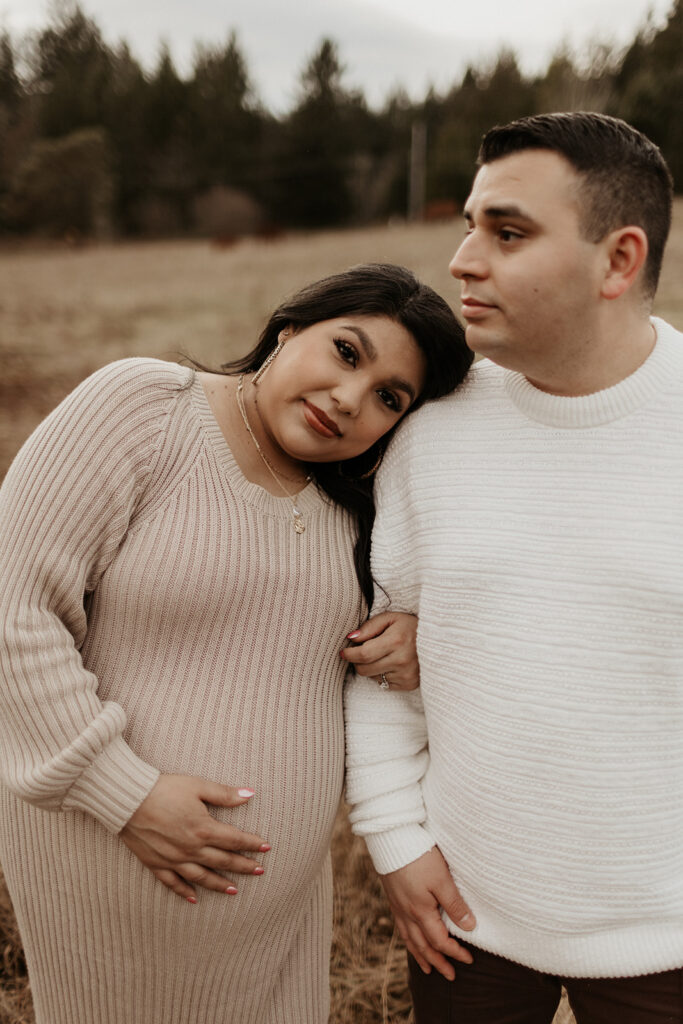 pregnant woman leans head on man's should during maternity shoot