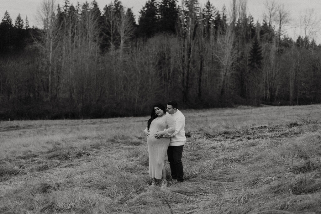 man and woman standing in field during gig harbor maternity shoot