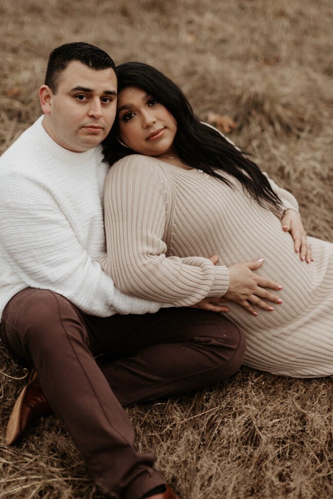 man and pregnant woman lay in brown field during gig harbor maternity  session