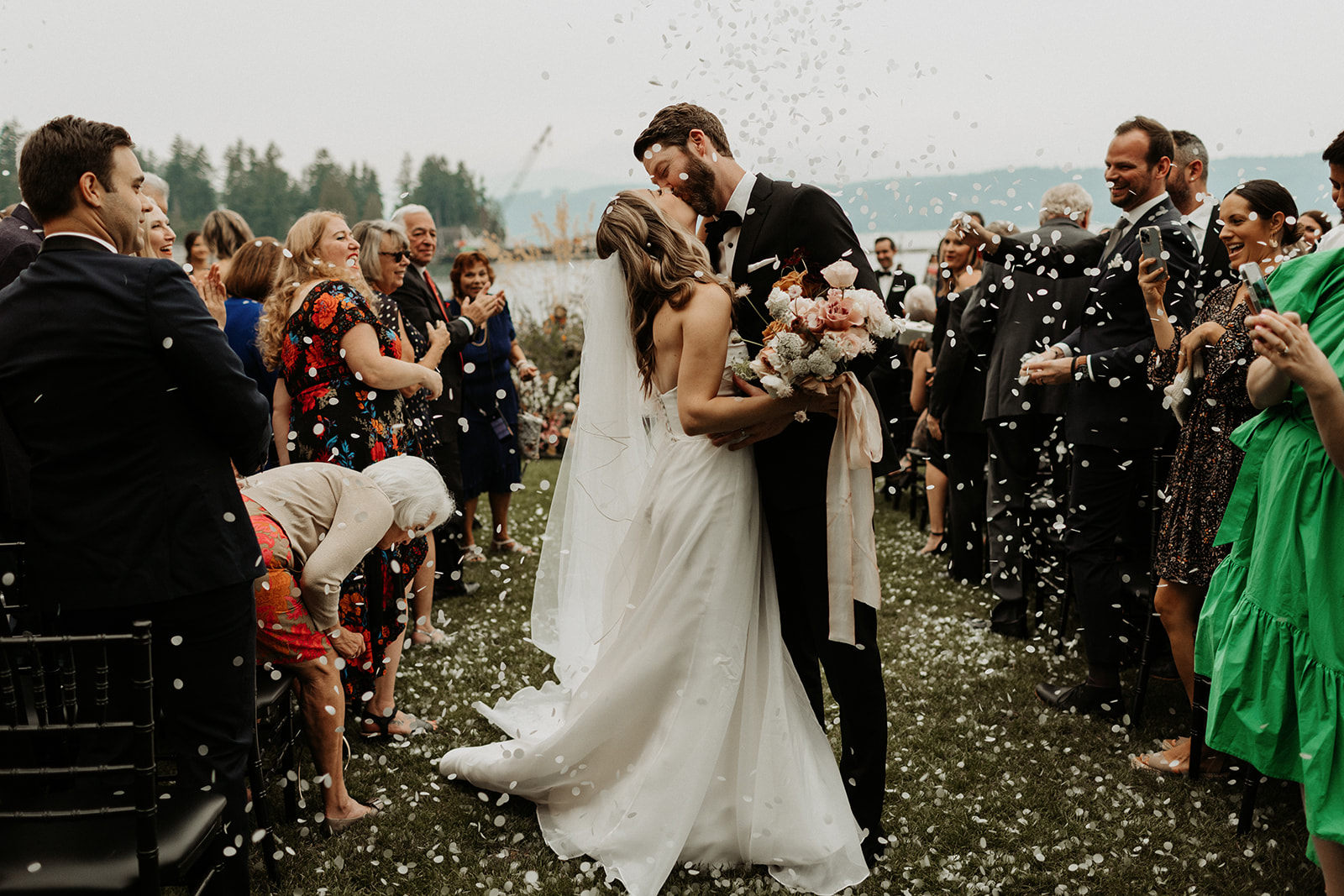 bride and groom kiss in aisle after ceremony at alderbrook resort wedding