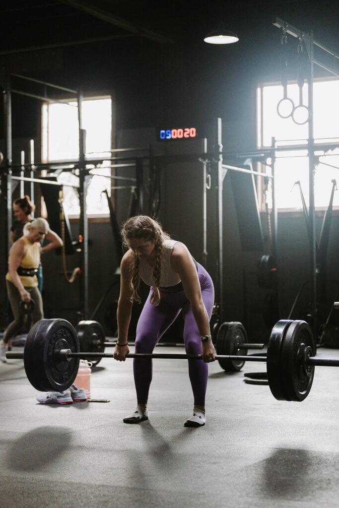 woman leaning over holding a barbell